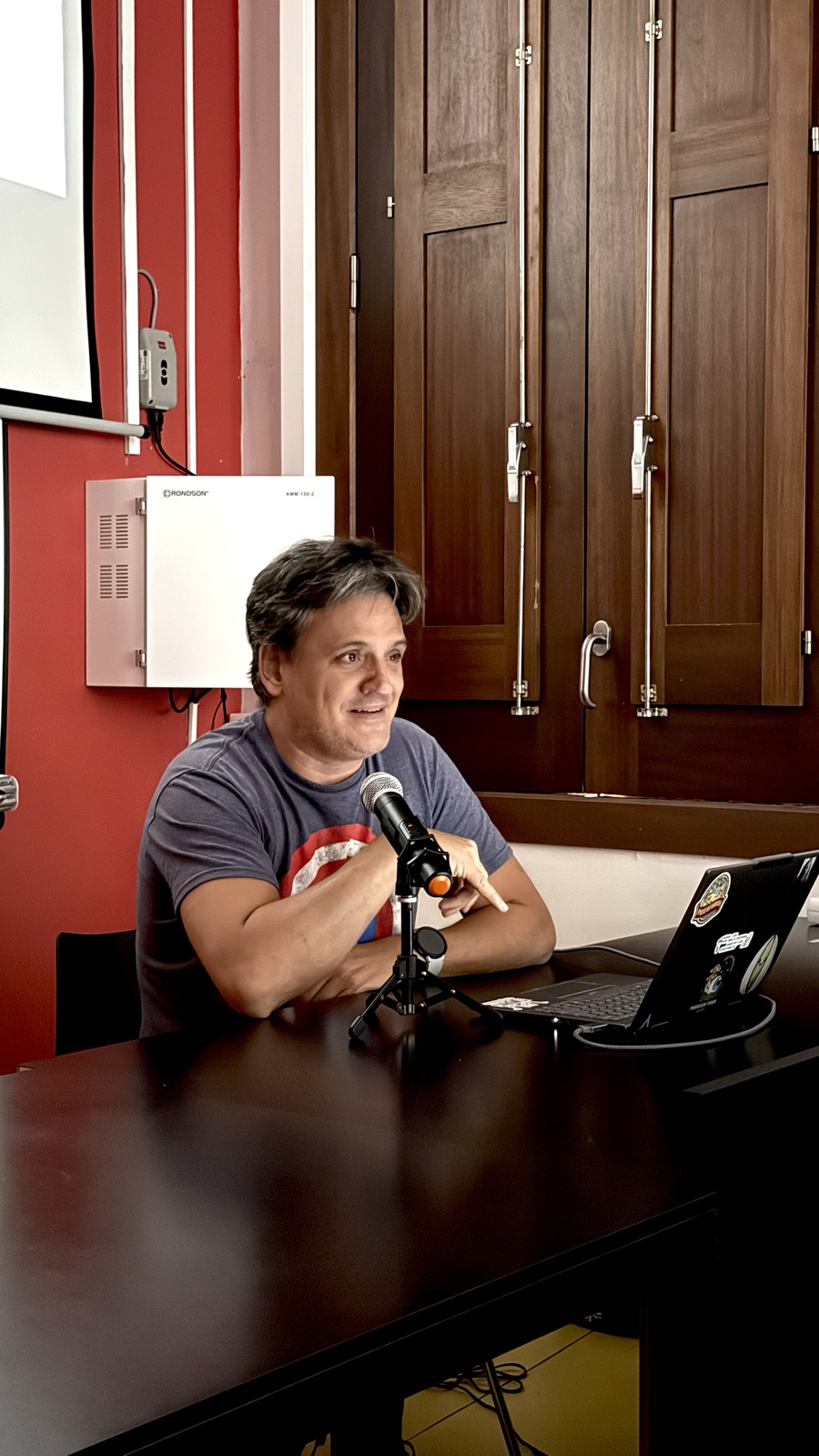 Eduard Vidal parlant, assegut davant d’un micròfon i un portàtil durant la seva xerrada