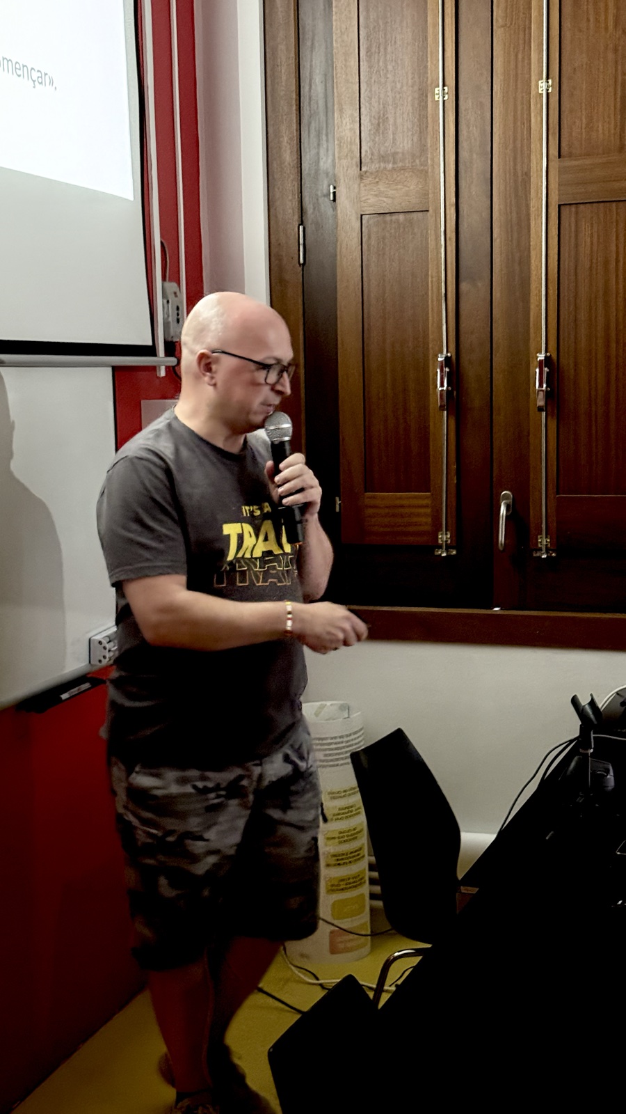 Ivan Reyné parlant amb un micròfon i un comandament de presentació durant la seva xerrada