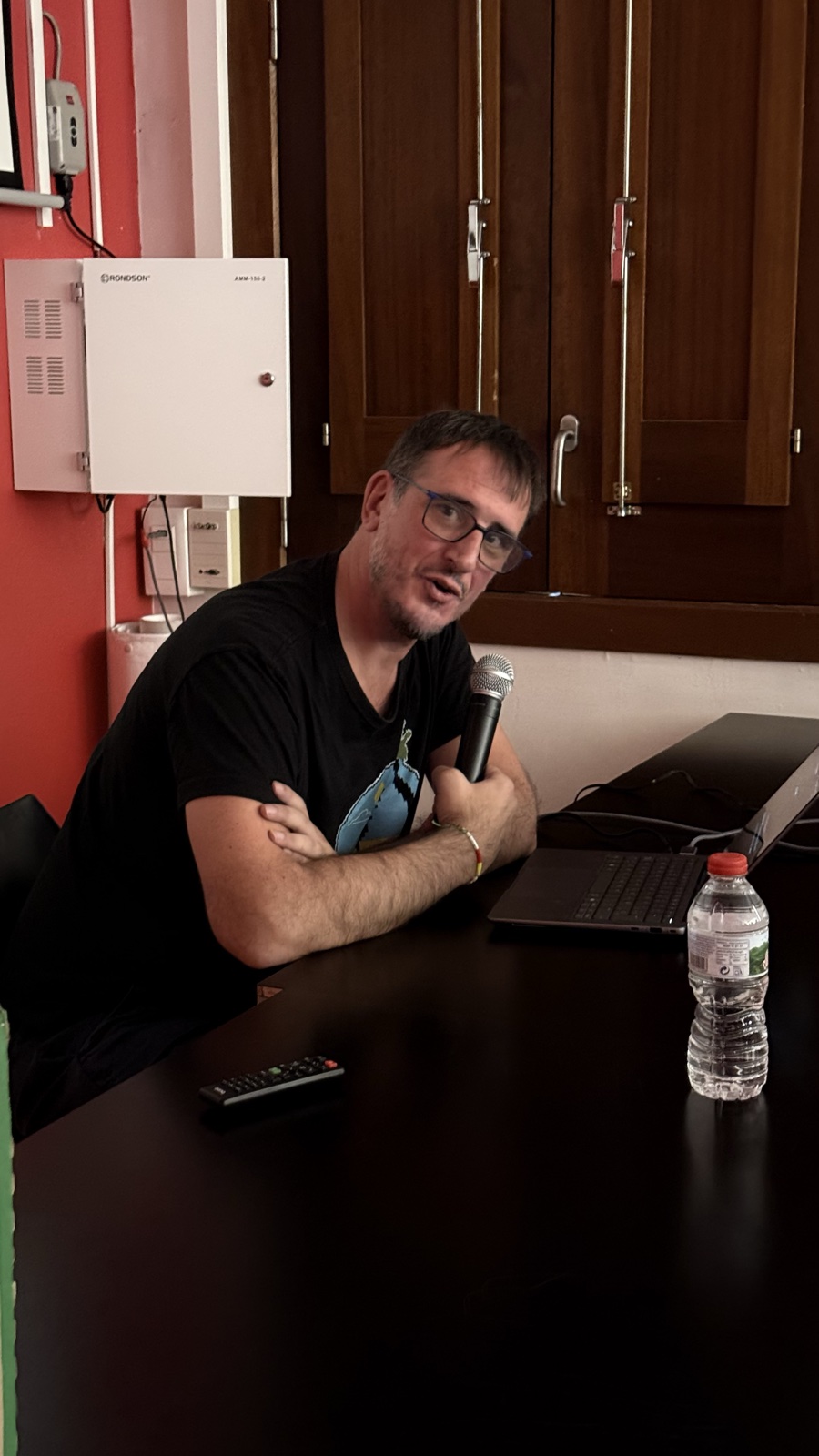 Jordi Mas parlant amb un micròfon, assegut davant del portàtil durant la seva xerrada