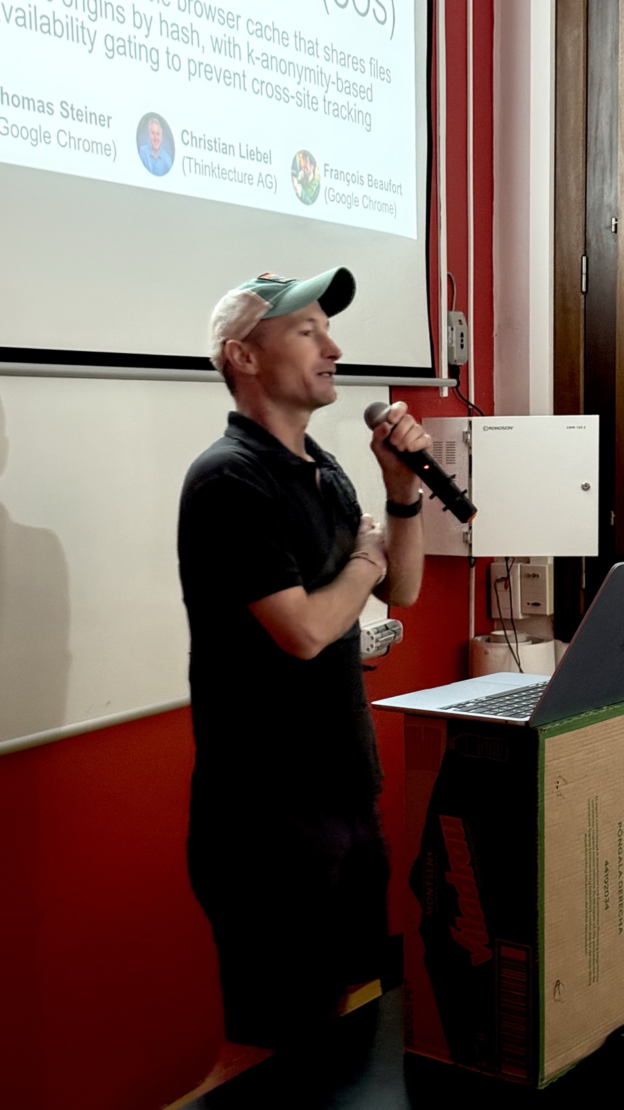 Thomas Steiner parlant amb un micròfon davant de la projecció de la seva xerrada